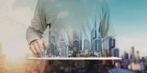 A Man Using Digital Tablet And Modern Buildings Hologram Real